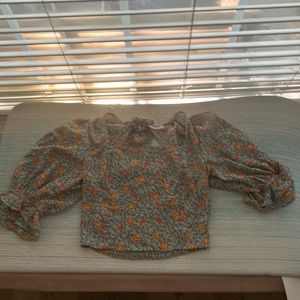 siena sky cropped puff sleeve top with ruffle ends.